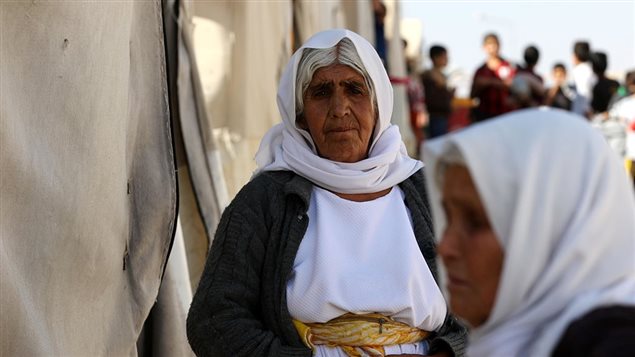 A displaced Iraqi woman from the Yazidi community, who fled violence between Islamic State (IS) group jihadists and Peshmerga fighters in the northern town of Sinjar, stands at a camp for internally displaced persons (IDP) in the Sharia area, some 15 kilometres from the city of Dohuk, on November 17, 2016.