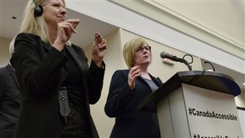 Une interprète à gauche traduit en langage des signes le discours de la ministre des Sports, Carla QualtroughPhoto: Justin Tang La Presse canadienne