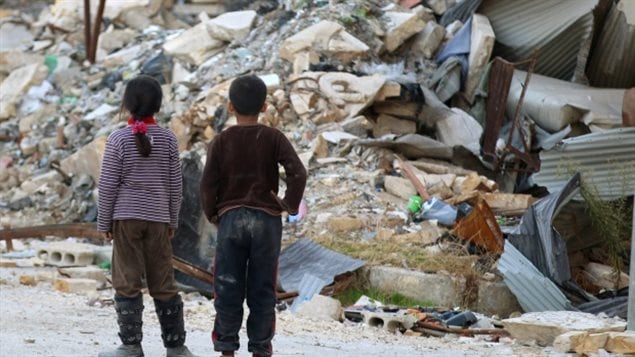 طفلان سوريّان يتجوّلان وسط الركام في منطقة واقعة تحت سيطرة المعارضة في حلب