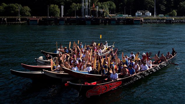 Members of the Squamish and Tsleil-Waututh First Nations gather in canoes on the waters of Burrard Inlet at the Kinder Morgan Burnaby Terminal for a ceremony to show opposition to the $5 billion expansion of the Trans Mountain pipeline, in North Vancouver, B.C., on Saturday September 1, 2012. 