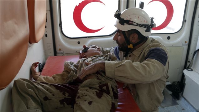 A civil defence member holds an injured boy inside an ambulance after what activists were were cluster bombs dropped by Russian air force in Maaret al-Naaman town in Idlib province, Syria October 7, 2015. 