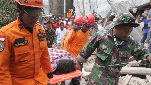 Indonesian rescue workers carry a survivor from a fallen building after an earthquake in Ulee Glee, Pidie Jaya, in the northern province of Aceh, Indonesia December 7, 2016.