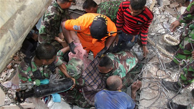 Indonesian rescue workers carry a survivor from a fallen building after an earthquake in Trienggadeng, Pidie Jaya, in the northern province of Aceh, Indonesia December 7, 2016.