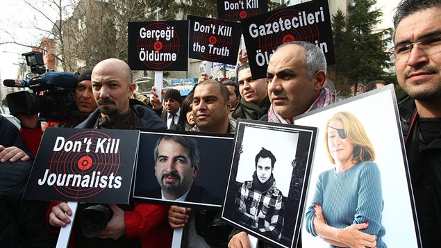 Turkish journalists in Ankara, on February 24, 2012, hold pictures of journalists who died covering the crisis in Syria.