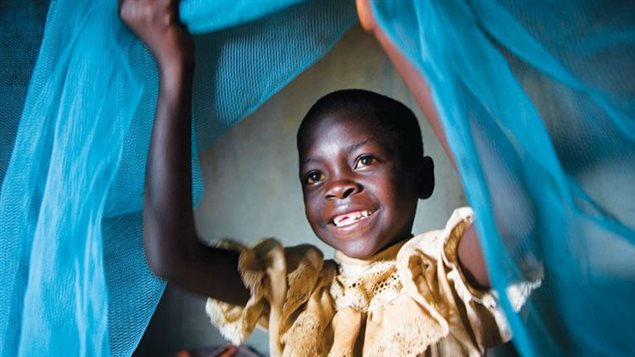 Une petite fille lève un filet contre la malaria 