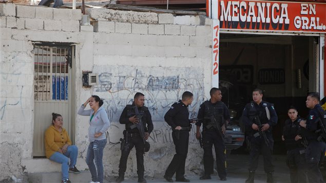 (Imágenes de Archivo) Dos mujeres de Ciudad Juárez esperan junto a los policías -el pasado 16 de diciembre- cerca del lugar donde fueron asesinados dos hombres. La violencia en Ciudad Juárez dejó 5 muertos esta navidad.  