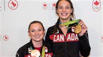 Gold medalists Penny Oleksiak, right, and Rosie MacLennan at Toronto's Pearson Airport on their return from Rio.