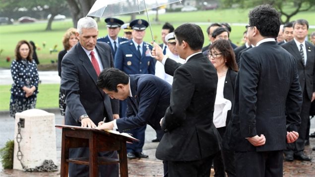 Shinzo Abe firma el libro de los invitados de honor del Cementerio Memorial Nacional del Pacífico.