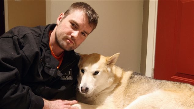 William Gibb cuddles up with his five year old husky, Sasha, for a portrait on Wednesday. On Boxing Day, Gibb rescued Sasha from the jaws of a cougar, beating it with his fists and a stick outside a Tim Hortons.