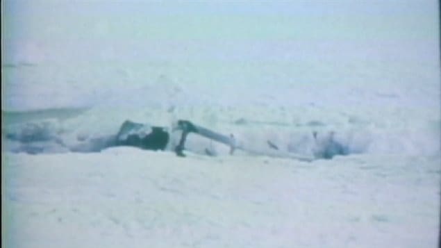 A piece of 954 sticking out of a small crater from impact and heat that it made in the ice. This initial piece was accidentally found by a group of civilians on an expedition.