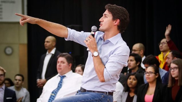 Le premier ministre Justin Trudeau répond aux des questions lors d’une réunion a la mairie à Calgary, en Alberta, où il est pressé par les citoyens de cette province pétrolière de soutenir les projets de pipelines et de développer les sables bitumineux. (Jeff McIntosh / Presse canadienne)