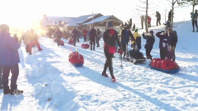 参加育空北极超级长跑的人拉着雪橇走上征程