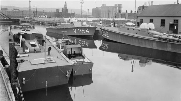Two MTB’s at right showing torpedo tubes and MG turrets. Moored at righ is a slighlty smaller High Speed Launch used to rescue downed pilots in the English channel and elsewhere. The building would be to the left.. Note the roadway lift bridge just at the upper left which gave the boats access to the Lachine Canal.