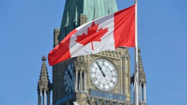 Canada’s unique and instantly recognizable Maple Leaf flag in front of the Victory and Peace Tower of Canada’s Parliament in Ottawa