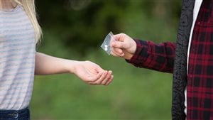 Une jeune fille achète de la drogue.