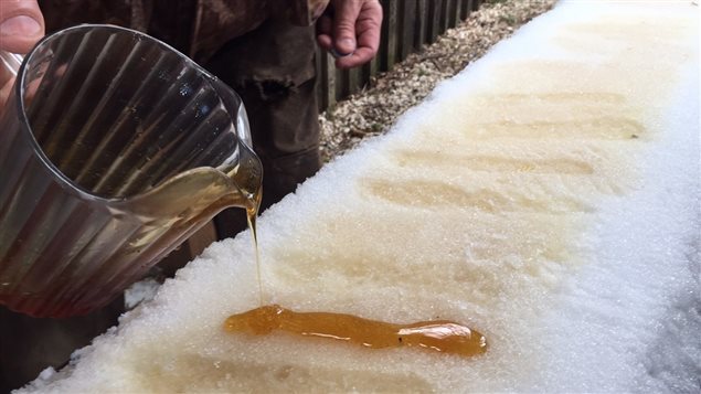 Snow-cooled toffee. Warm maple syrup is poured onto a packed snow surface where the liquid cools to a soft sticky toffee, A popsicle stick/coffee stir stick is then stuck into it and it is lifted from the snow and wound around the stick to create a sort of soft maple toffee lollipop,