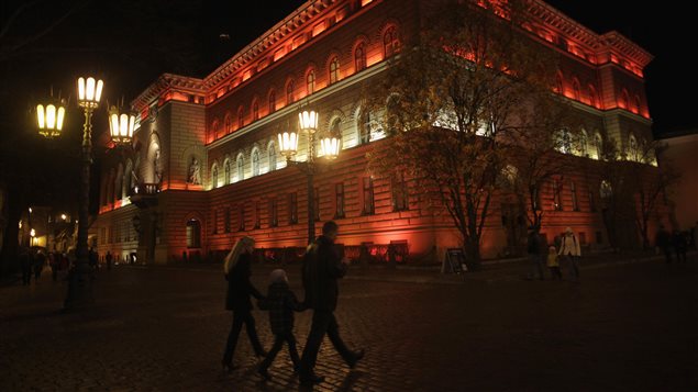 People walk past an illuminated parliament building in Riga November 18, 2011. Latvia became the first EU country to ratify the Comprehensive Economic and Trade Agreement with Canada on Feb. 23, 2017.