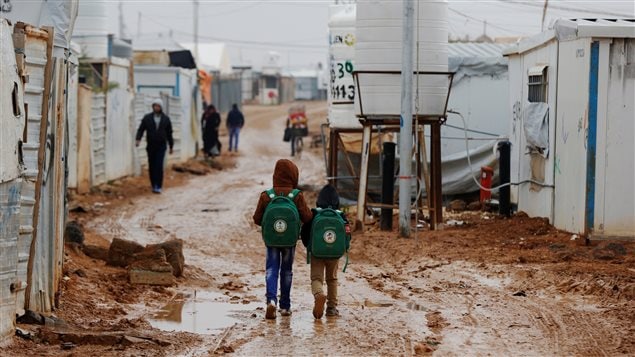 Syrian refugee children walk to the school during rainy weather at the Al Zaatari refugee camp in the Jordanian city of Mafraq, near the border with Syria December 18, 2016.