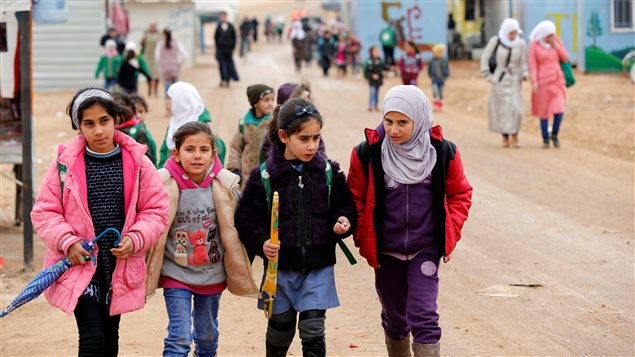 Syrian refugee children walk to the school during rainy weather at the Al Zaatari refugee camp in the Jordanian city of Mafraq, near the border with Syria December 18, 2016.