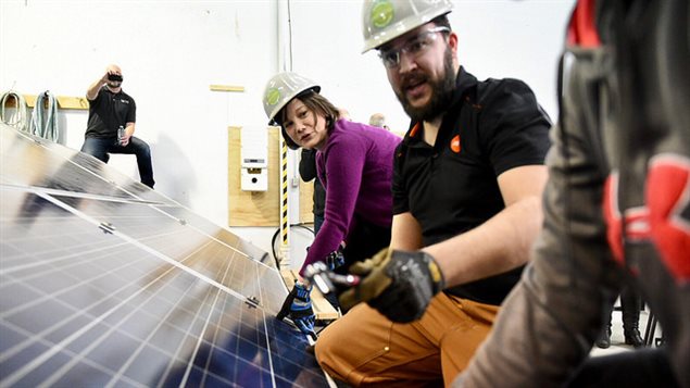 La ministre Shannon Phillips aide à l’installation des paneaux solaires au centre d’entraînement Gridworks Solar Energy Training Centre en Alberta