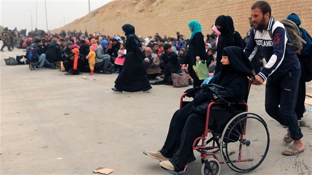 نازحون من منطقة الموصل ينتظرون أمس نقلهم إلى مناطق أكثر أمناً.