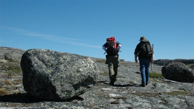 Les chercheurs Jonathan O’Neil et Don Francis reviennent au camp avec des sacs à dos remplis d’échantillons de roche. (Alexandre Jean)