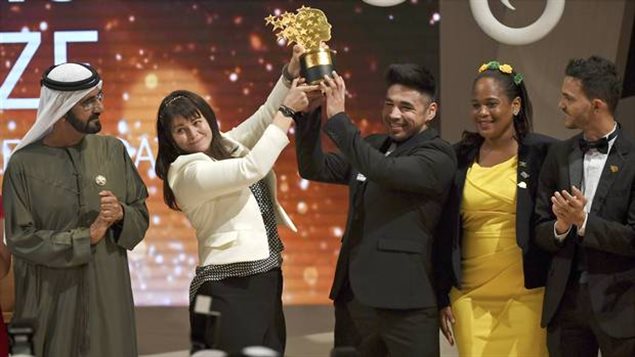  Maggie MacDonnell raises the Global Teacher Prize with one of her students while standing next to Dubai ruler Sheikh Mohammed bin Rashid Al Maktoum, in Dubai, United Arab Emirates.