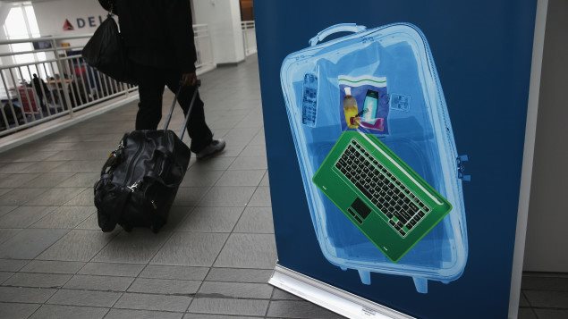 Une valise contenant un ordinateur portable devant un voyageur Photo : Getty Images/John Moore
