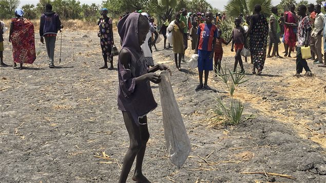 Lulu Yurdio gets food aid for himself and family members who are hiding in the bush in Padeah, South Sudan. They have fled famine and fighting in Leer county.