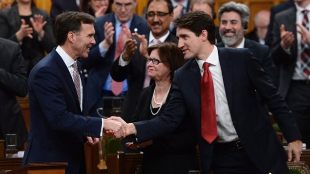 Le premier ministre Justin Trudeau, à droite, serre la main au ministre des Finances, Bill Morneau, après avoir déposé le budget fédéral à la Chambre des communes mercredi. (Sean Kilpatrick / Presse Canadienne)
