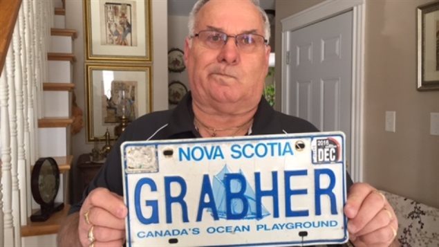 Lorne Grabher手举自己被吊销的姓氏车牌
