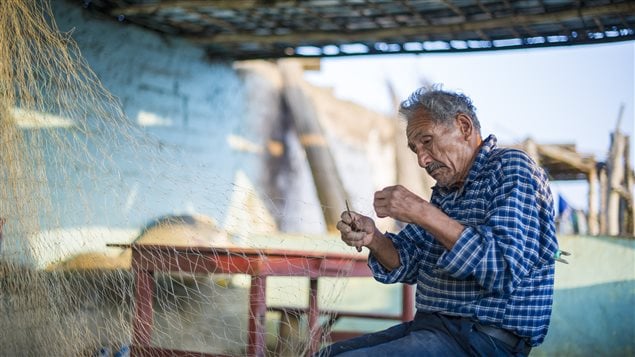 Pescador peruano preparando y reparando su atarraya.