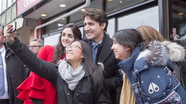 Prime Minister Justin Trudeau poses for photos as he campaigns with Liberal candidate Emmanuella Lambropoulos, left, for the byelection in the Saint- Laurent riding, Sunday, March 26, 2017 in Montreal.