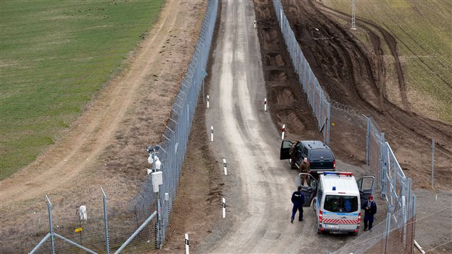 Agentes de policía húngaros patrullan la frontera con Serbia, donde se construyó una segunda cerca de alambre de púas cerca del pueblo de Gara.