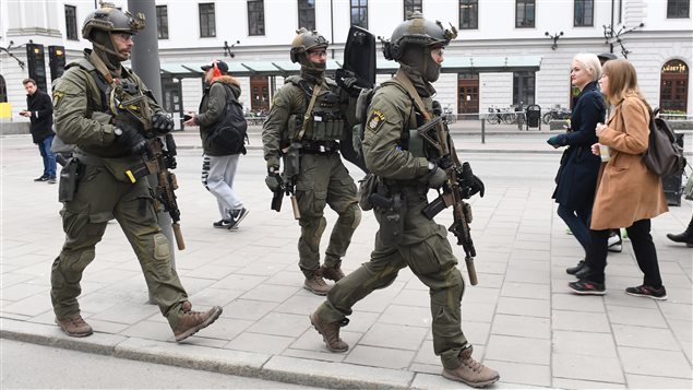 Armed police patrol outside the central station in Stockholm after a truck crashed into a department store injuring several people in a different part of Stockholm, Sweden, Friday April 7, 2017.