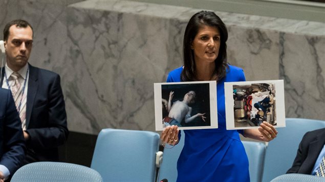  U.S. Ambassador to the United Nations Nikki Haley holds up photos of victims of the Syrian chemical attack during a meeting of the United Nations Security Council at U.N. headquarters, April 5, 2017 in New York City.