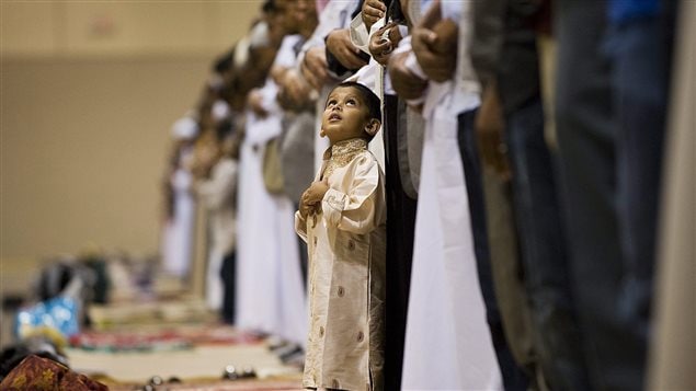 Zubar Karamat, 3, looks up during prayer at the Muslim Association of Canada’s Eid celebration at the Metro Convention Centre in Toronto on Tuesday, August 30, 2011.