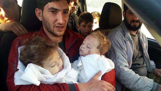 In this Tuesday April 4, file photo, Abdel Hameed Alyousef, 29, holds his twin babies who were killed during a suspected chemical weapons attack, in Khan Sheikhoun in the northern province of Idlib, Syria. Canada has responded by placing sanctions on some Syrian officials.