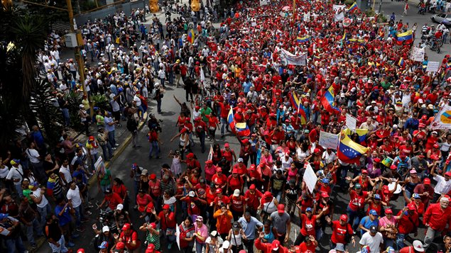 Manifestantes de la oposición y partidarios de Nicolás Maduro se cruzan en sus manifestaciones este 19 de abril 2017. 