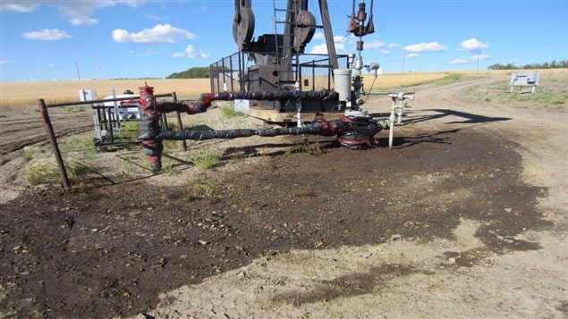 Active oil well that appears to have suffered a blow out. The ground around the wellhead is soaked with oil and wellhead and attached pipes are wrapped in plastic sheathing