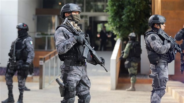 Policías armados motan la guardia frente al edificio donde se capturó a Dámaso *El Licenciado* López en Ciudad de México.