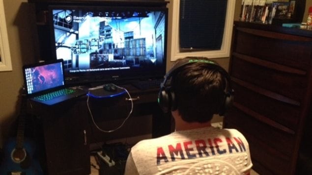 Teen, plays video games in his bedroom. Too often we become absorbed in the devices and isolate ourselves. Studies have shown that humans benefit in many ways from communication in person with others.