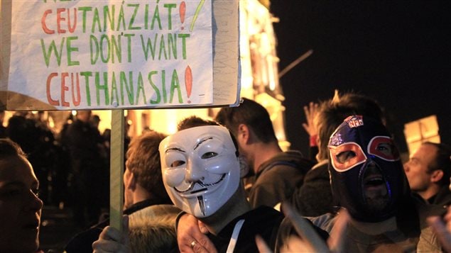 A man wearing Guy Fawkes mask holds placard as he protests in front of the Hungarian Parliament against a new law that would undermine Central European University, a liberal graduate school of social sciences founded by U.S. financier George Soros in Budapest, Hungary, April 12, 2017. 