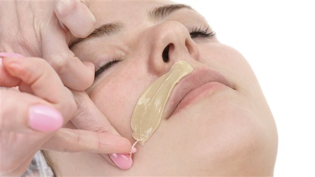 Une femme se fait épiler la lèvre supérieure. Une femme se fait épiler la lèvre supérieure.