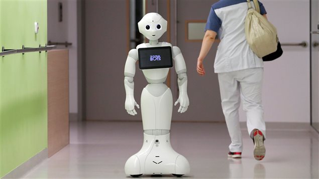 A nurse walks by new recruit *Pepper* the robot, a humanoid robot designed to welcome and take care of visitors and patients, at AZ Damiaan hospital in Ostend, Belgium June 16, 2016.