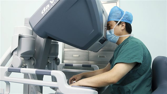 A doctor operates on a patient with a surgical robot in Hefei, Anhui province September 24, 2014. 