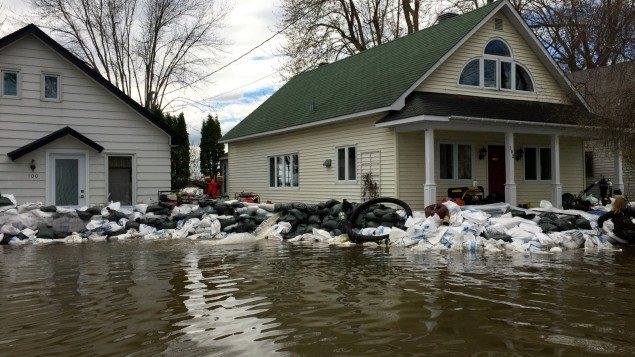 Dos casas rodeadas de diques de bolsas de arena en Oka, Quebec. 