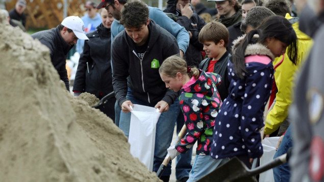 El primer ministro de Canadá, Justin Trudeau, llena una bolsa de arena para construir diques en Terrasse-Vaudreuil, Quebec.