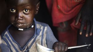 A boy eats out of a ladle at his home in Ngop in South Sudan’s Unity State on March 10, 2017.
