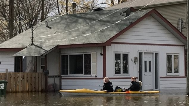 La familia regresa en kayak para recuperar algunas cosas en su casa inundada. 